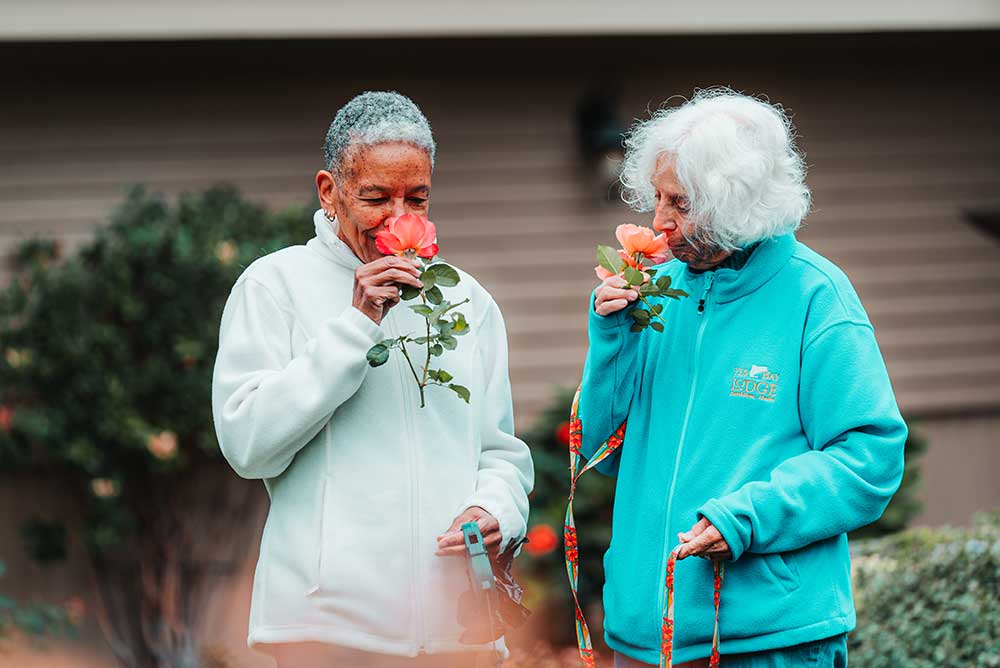 women smelling flowers