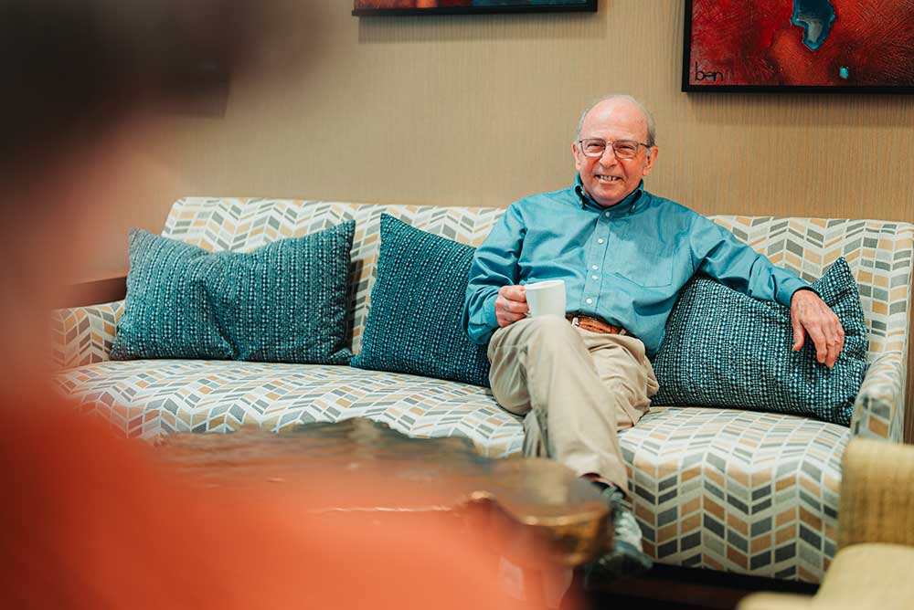 man drinking coffee on his couch