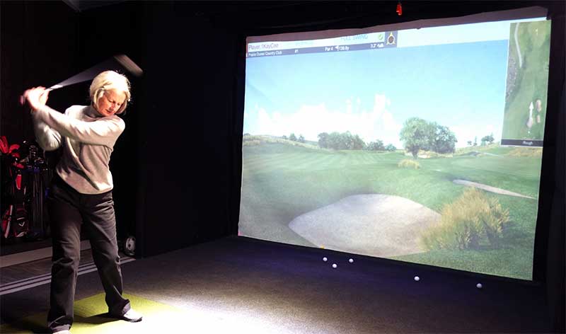 Woman playing simulated golf