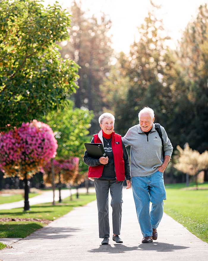 Man and woman walking down the sidewalk at Whitworth University