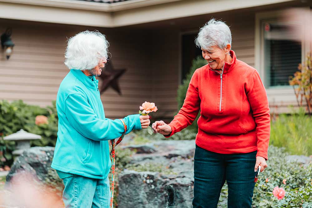 woman giving another woman a flower