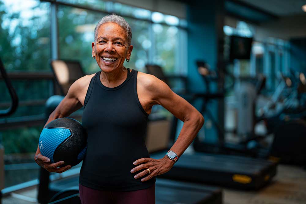 woman smiling in front of treadmills